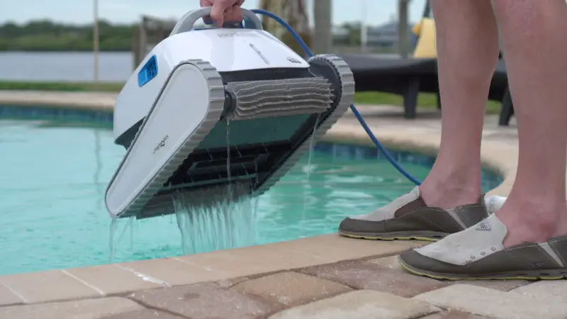 Man removing to robotic pool cleaner from the pool Dolphin Proteus DX4 Review