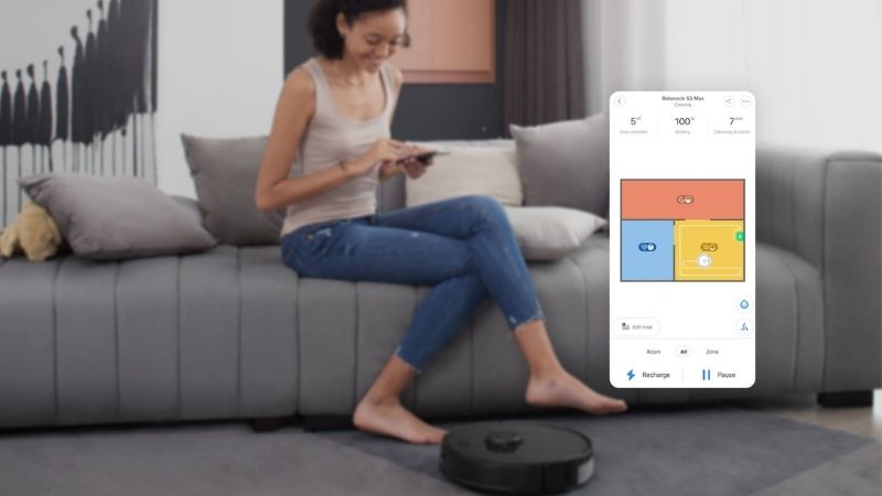 Roborock S5 MAX vs S6, a lady on a couch controlling her vacuum via the app