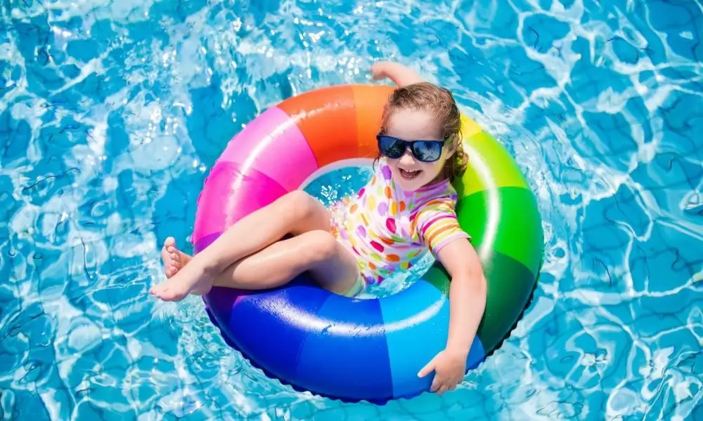 A girl floating in a swimming pool, america's swimming pool company