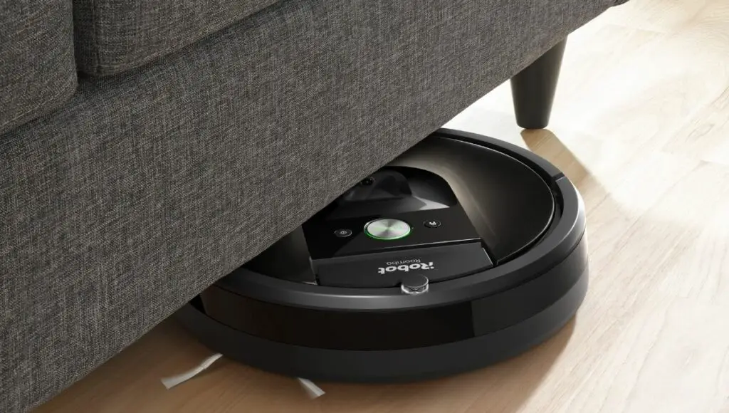 A robot roomba robot vacuum cleaning under the furniture