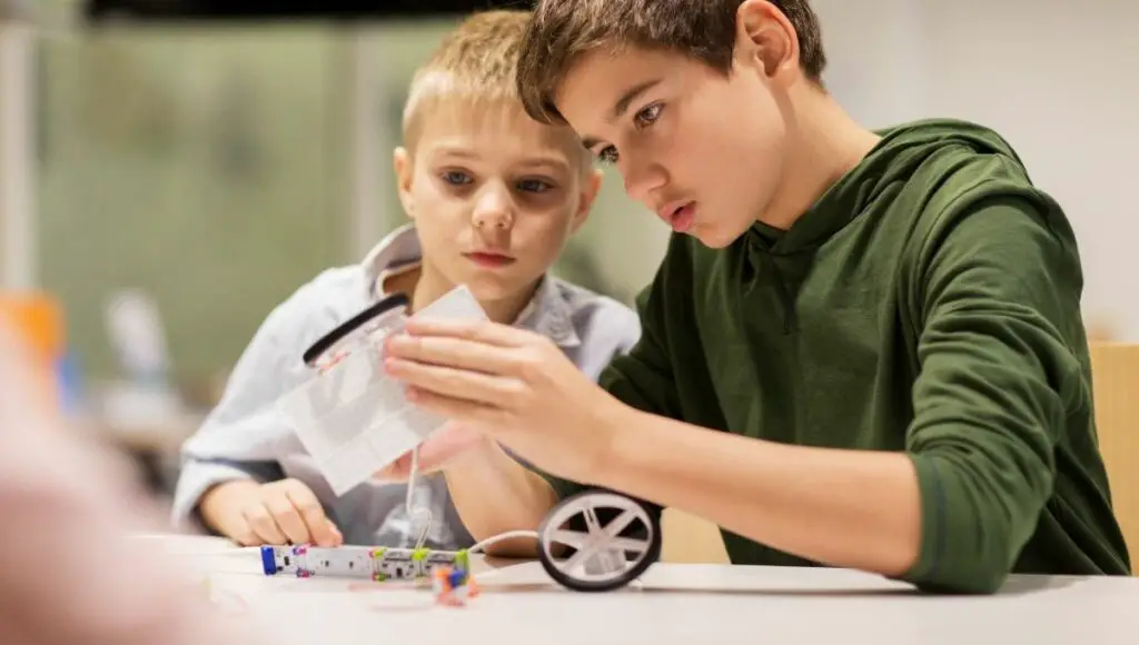 Two boys assembling their great coding gifts robots