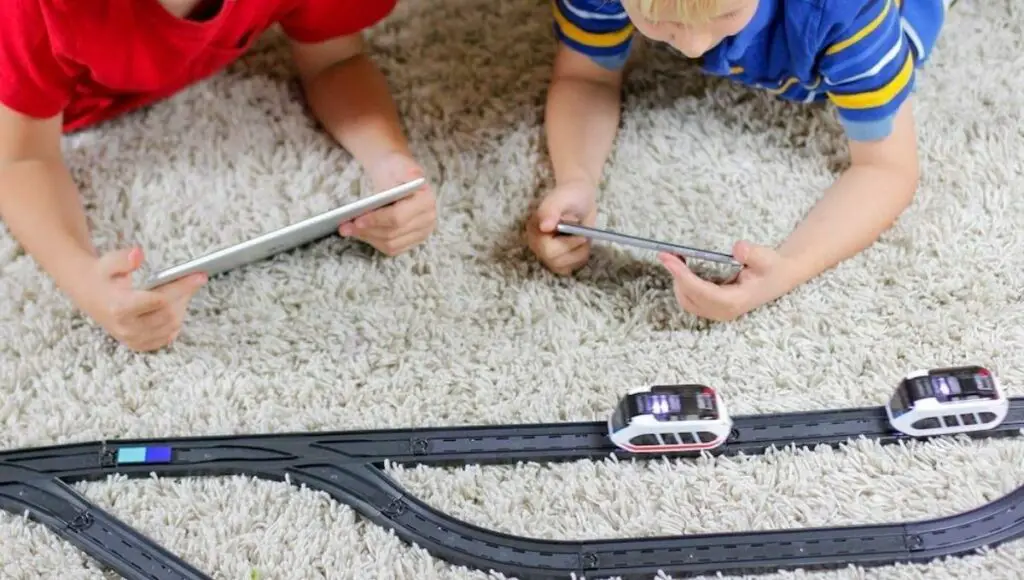 Two kids play with their intelino robot train toy