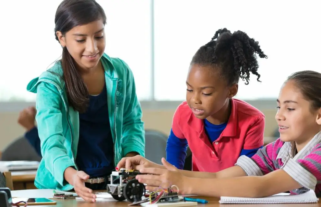 Three girls building the best solar robot kit as part of a STEM learning project