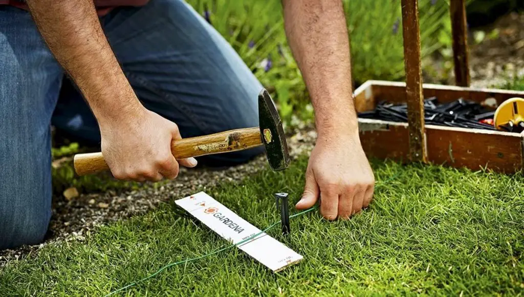 A man making a boundary for the protection of robotic lawn mower