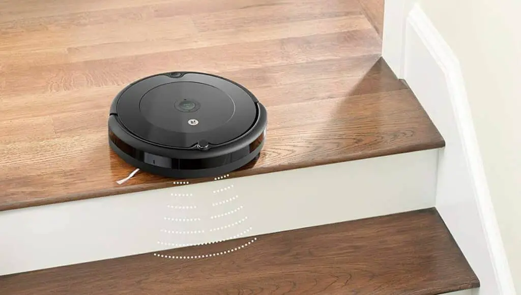 A roomba robot vacuum cleaner by the stairs