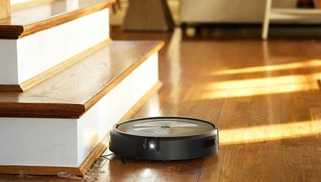 A roomba robot vacuum cleaner cleans the dirt under the stairs
