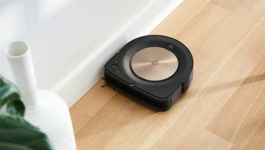 A roomba robot vacuum cleaner vacuuming in wood floor