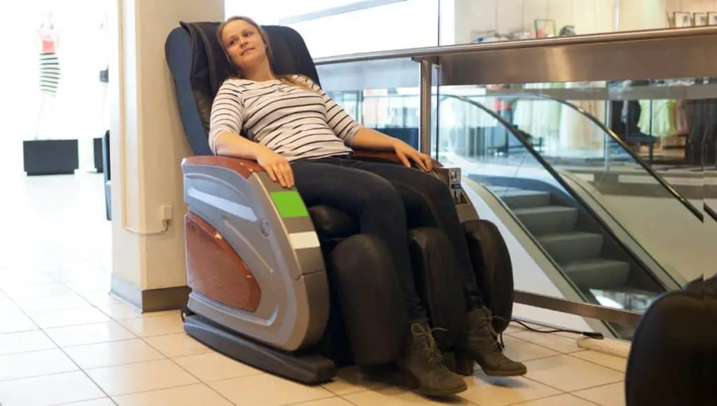 A woman resting in the massage chair at the mall